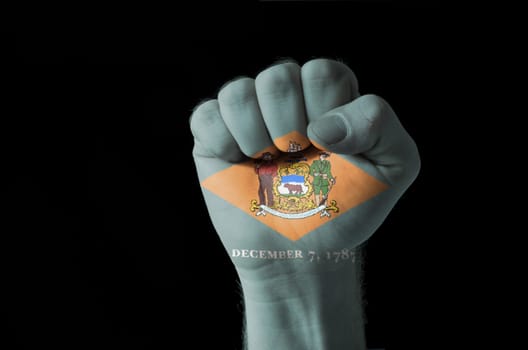 Low key picture of a fist painted in colors of american state flag of delaware