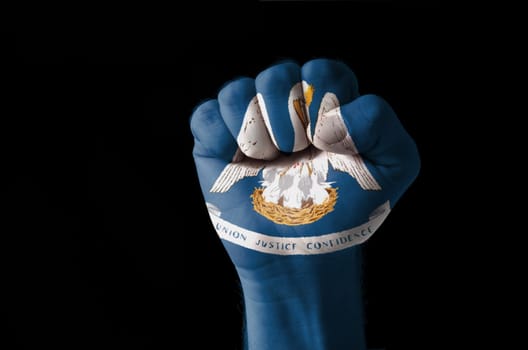 Low key picture of a fist painted in colors of american state flag of louisiana