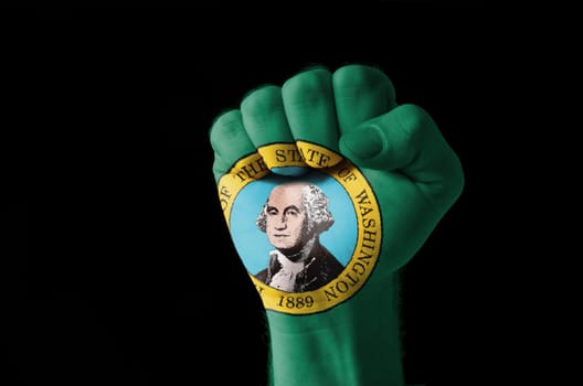Low key picture of a fist painted in colors of american state flag of washington