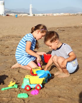 Kids playing with plastic toys on the beach