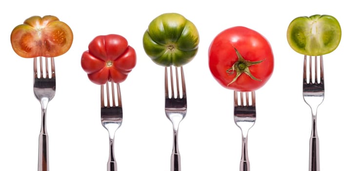 Five different tomatoes in red and green on a fork