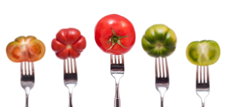 Five red and green tomatoes with fork