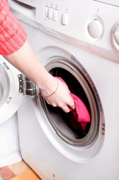 Young woman loading the washing machine