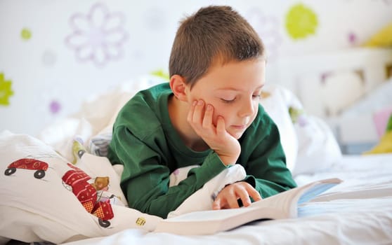 boy reading a book in bed