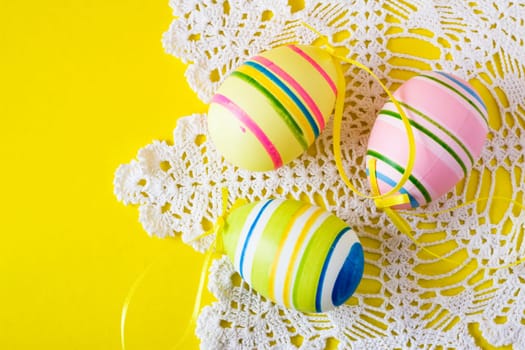 three colorful easter eggs on decorative serviette