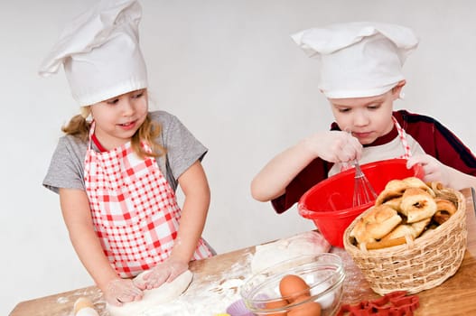 two children in chef&#039 s hats on grey background