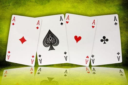 four aces with reflection on green background