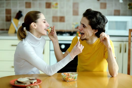 An image of young couple eating at kitchen