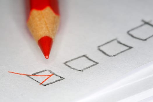 Closeup image of red pencil laying on sheet of paper