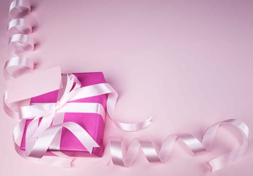 Gift box with ribbon on pink background