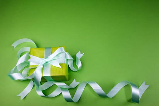 Gift box with ribbon on green background