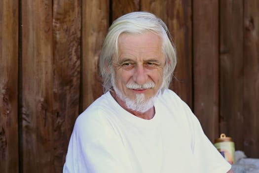 Good looking, smiling old gray man in a white T-shirt