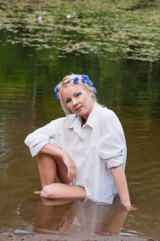 Outdoor shoting of beautiful young caucasian woman sitting in water