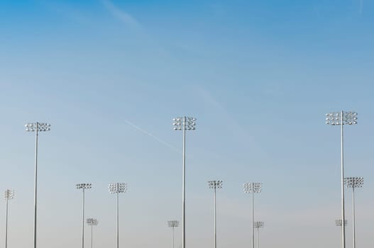 Cropped shot of illumination towers from behind, with blue sky and loads of copy space