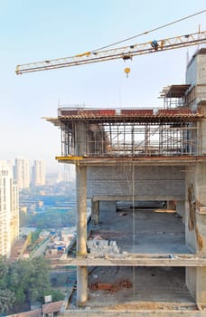 Crane over a righ rise office block on construction site in Mumbai