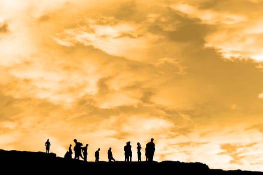 Silhouette of crowd of people on the peak edge of a cliff in ireland with clipping path