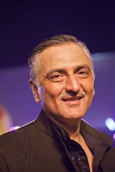 Chivas Regal workshop, Mumbai, India December 10, 2011:  Vertical portrait of Rakesh Thakore under colored lights, renowned Indian textiles designer, partner in Abraham &amp  Thakore