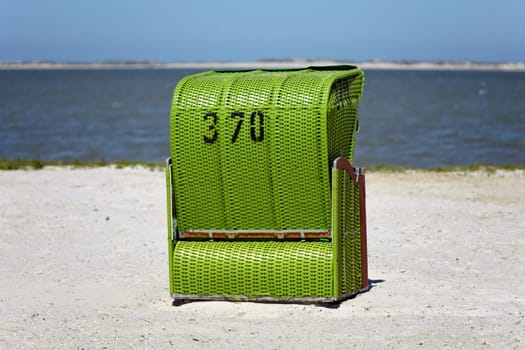 Green single beach chair on the beach of the Baltic Sea