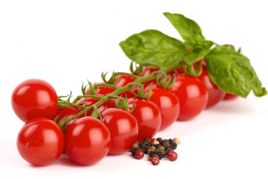 Cherry tomatoes with peppercorns isolated against white background