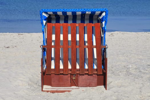 Single blue and white striped beach chair on the Baltic Sea