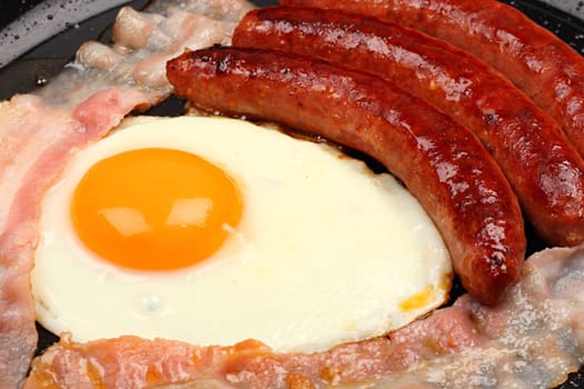 Fried egg and bacon in a frying pan.