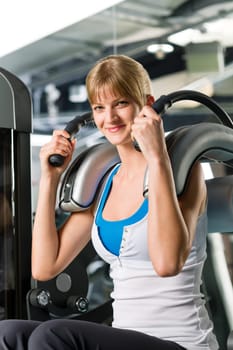 Young woman at fitness center exercise abdominal muscle gym machine