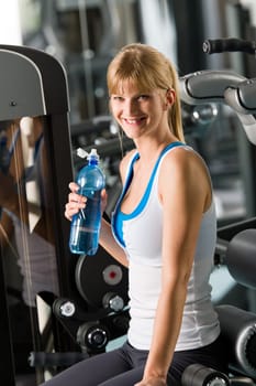 Young woman relax at the gym sitting on fitness machine