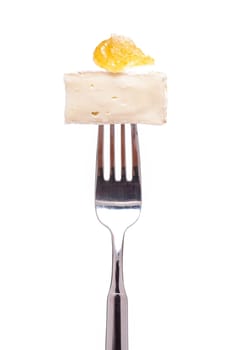 A Gamembert cheese with fig mustard on a fork