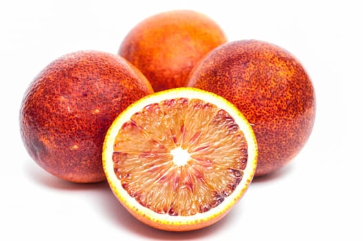 Four Moro blood oranges,one of which is sliced open