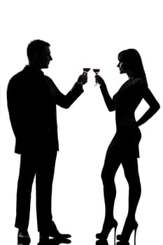 one caucasian couple man and woman drinking red wine toasting in studio silhouette isolated on white background