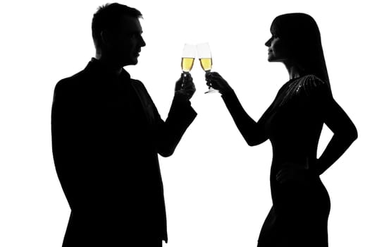 one caucasian couple man and woman drinking champagne toasting partying in studio silhouette isolated on white background