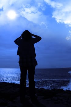 a lone woman looking sadly over the cliffs edge in county clare ireland