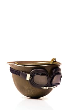 Old soldiers helmet with goggles isolated in white