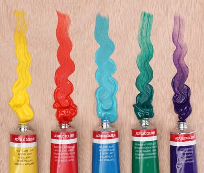 Five paint tubes over a pallete