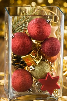 mixed christmas ornaments in big glass vase close up