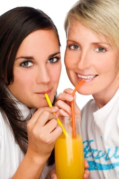 two young woman drinking orange juice close up