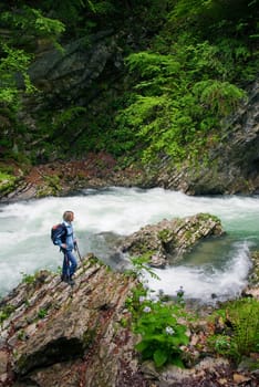 young woman hiking beside river in beautiful canyon