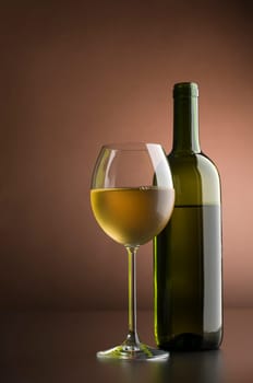 Bottle with white wine and glass close up