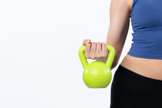 Vigorous energetic woman doing kettlebell weight lifting exercise on isolated background. Young athletic asian woman strength and endurance training session as body workout routine.