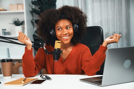 Host channel of beautiful African woman talking in online broadcast teaching marketing influencer, with listeners in broadcast or online. Concept of anywhere at work place. Tastemaker.