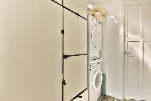 a laundry room with a washer and dryer on the wall next to an open door that leads to a closet