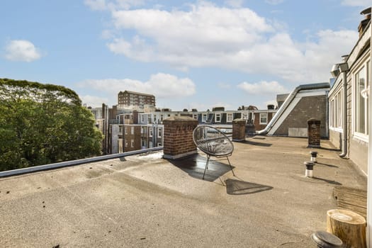 an old airplane on the roof of a building with trees and buildings in the background under a bright blue sky