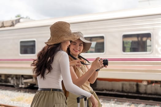 Two young female traveler on the train station, Travel lifestyle and seasonal vacation concept.