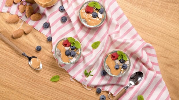 Chia pudding with oat and berries in a glass jar on rustic background.