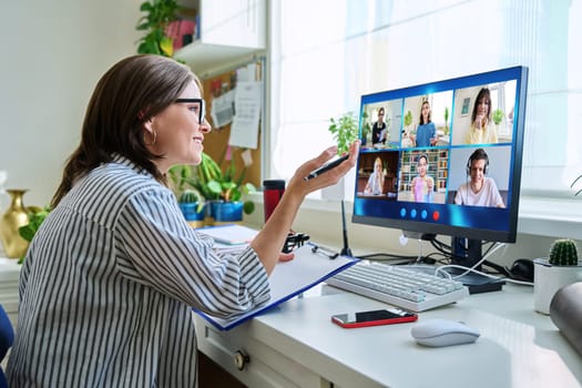 Female teacher working at home remotely, online lesson with group teenage students, teaching looking at computer screen sitting at home. Distance virtual class course interactive lesson video conference