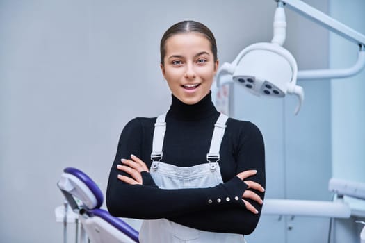 Portrait of young smiling teen girl in dental office looking at camera. Teenage female patient on examination treatment. Adolescence, hygiene, dental health care