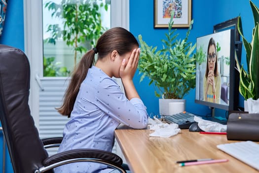 Teenage upset crying girl on online therapy with a psychologist. Sad female sitting at home talking on video conference chat with counselor therapist. Adolescence, psychology, psychotherapy, therapy