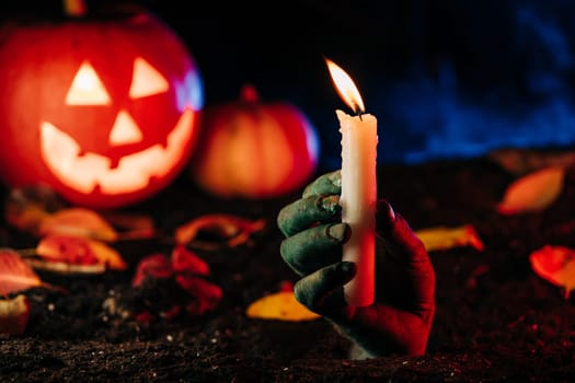 Horrible zombie hand emerges from grave on cemetery. Undead looking for victim. Terrifying scene underground, halloween concept. High quality