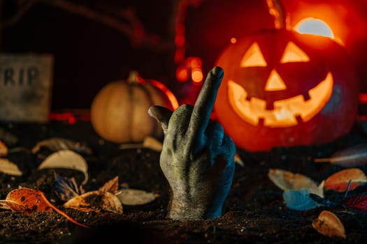 Terrible zombie with middle finger - gesture of fuck. Hand climbs out of grave. Creepy moment from undead life. Halloween concept. Living nightmare comes to life. High quality