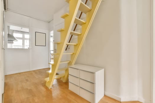 an empty room with some stairs in the middle part of the room is white and there is a yellow staircase leading up to the